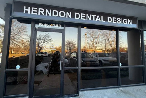 The image shows a storefront with a sign that reads  Henderson Dental Design,  indicating the name of the business located within the building.